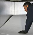 contractor installing TerraBlock™ floor insulation in a Mason crawl space
