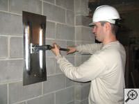 Attempting to straighten a bowed foundation wall by straightening a wall anchor system in a Mason home.