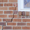 long jagged cracks starting at the corner of a window along a brick wall on a Oxford home