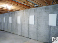 Wall anchor covers installed along a foundation wall that has been straightened in Fort Thomas.