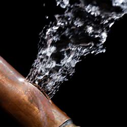 A bursting copper pipe in Middletown, with water gushing out.