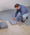 Contractors installing basement subfloor tiles and matting on a concrete basement floor in Loveland, Ohio and Indiana