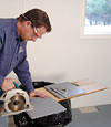 installing a waterproof vapor barrier on a basement floor to prepare for basement carpeting in a Middletown home
